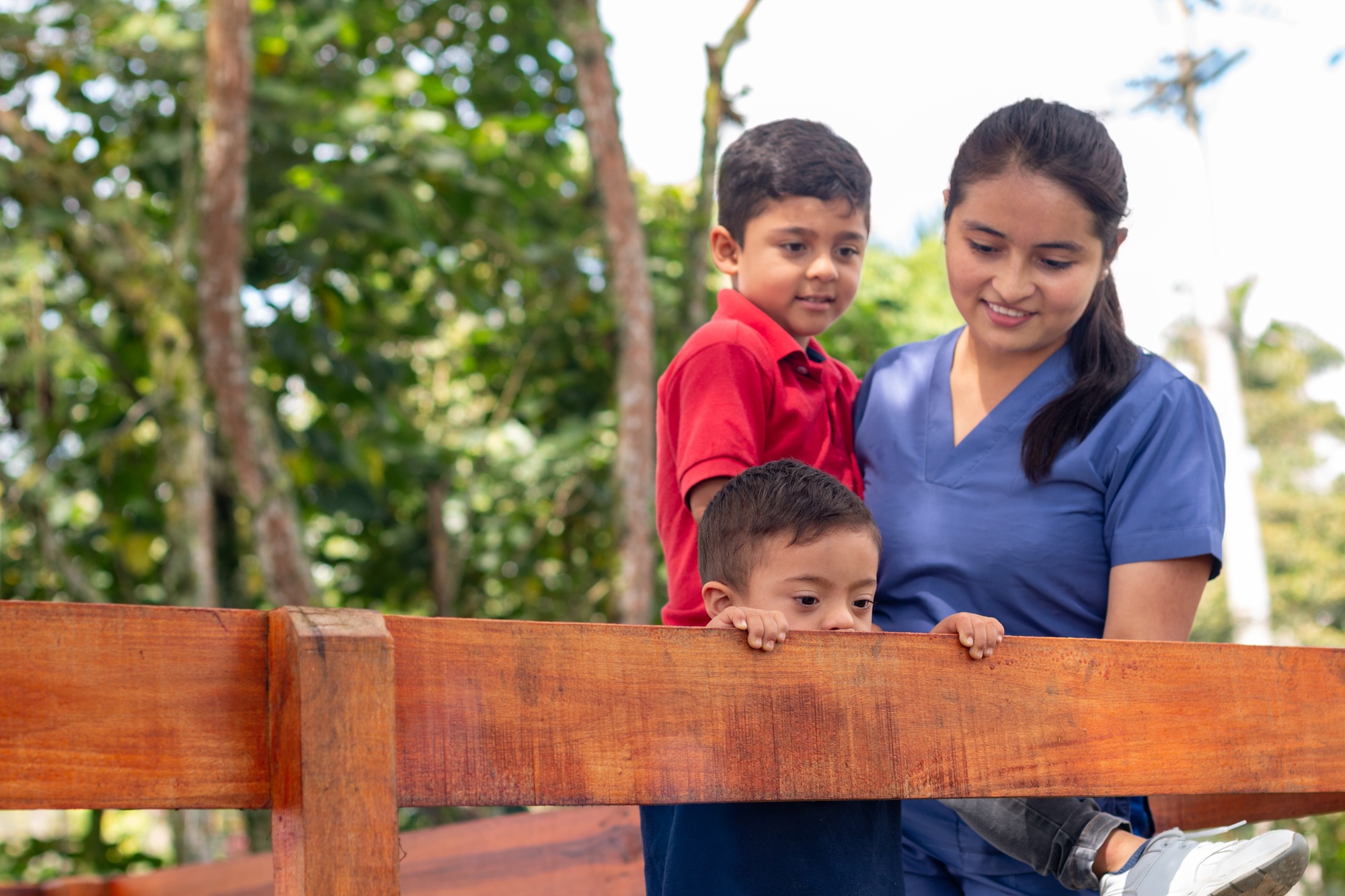 Focusing on a child with Down syndrome cared for by a pediatrician and his older brother.